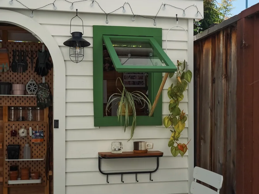 A wall-mounted potting station with a fold-down surface, hanging tools and a small shelf of plants.