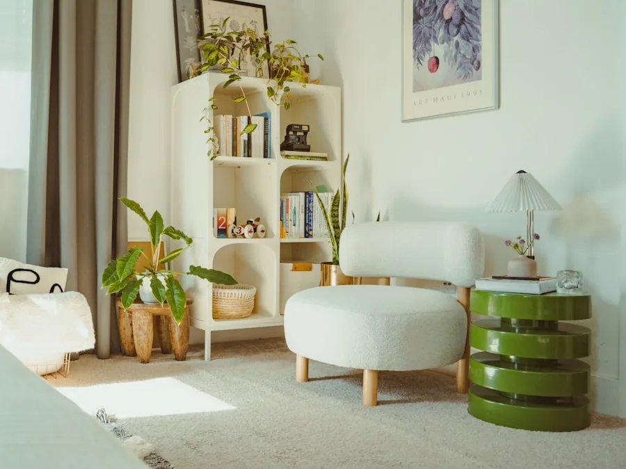 A round side table beside a low armchair in a bright room of pale walls and plants.
