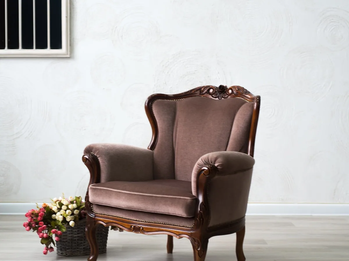 The Ashford high-seat armchair, upholstered in warm brown, standing against a pale wall.